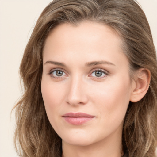 Joyful white young-adult female with long  brown hair and blue eyes