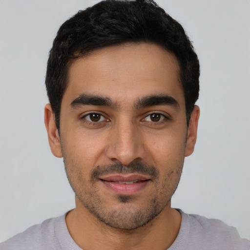 Joyful latino young-adult male with short  black hair and brown eyes