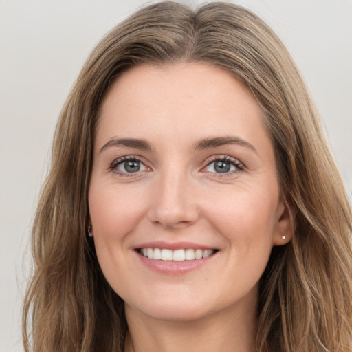 Joyful white young-adult female with long  brown hair and grey eyes