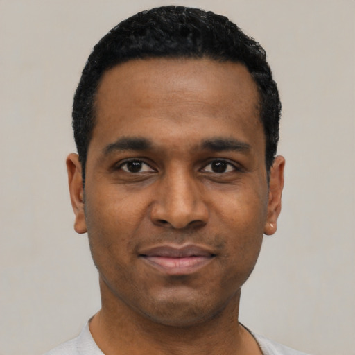 Joyful latino young-adult male with short  black hair and brown eyes