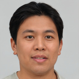 Joyful asian young-adult male with short  brown hair and brown eyes