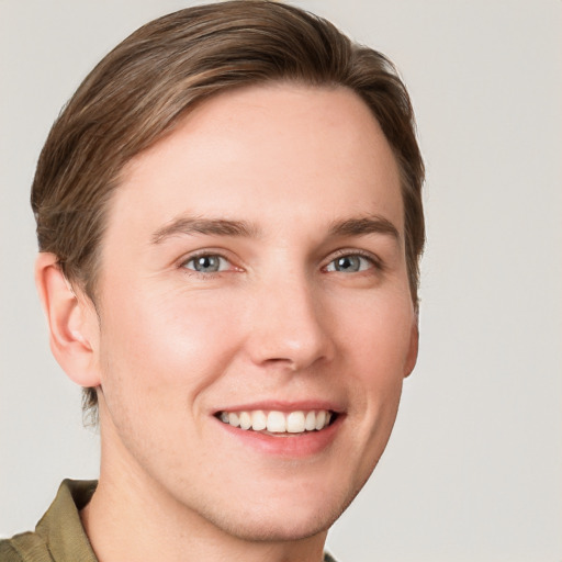 Joyful white young-adult male with short  brown hair and grey eyes