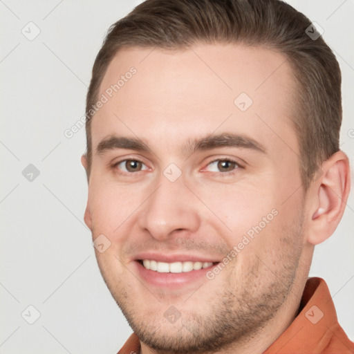 Joyful white young-adult male with short  brown hair and brown eyes