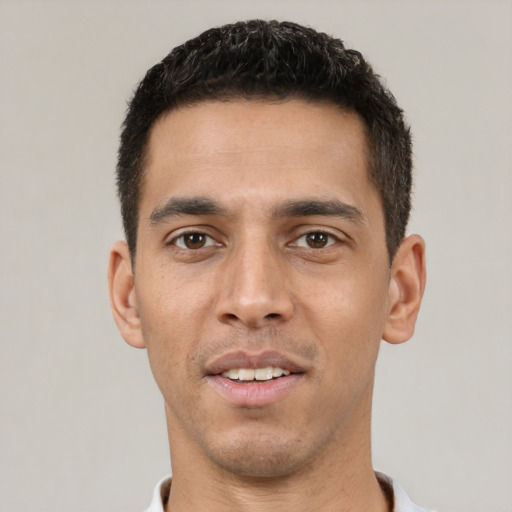 Joyful white young-adult male with short  black hair and brown eyes
