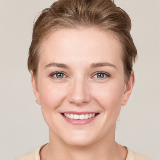 Joyful white young-adult female with short  brown hair and grey eyes