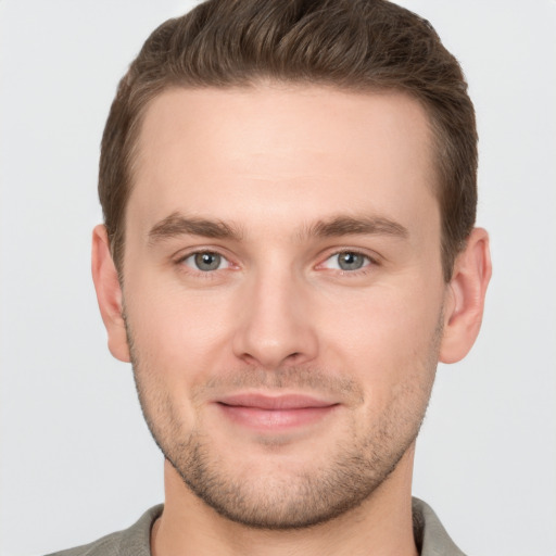 Joyful white young-adult male with short  brown hair and grey eyes