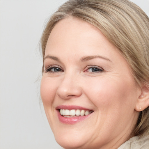 Joyful white young-adult female with medium  brown hair and blue eyes