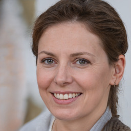 Joyful white adult female with medium  brown hair and grey eyes