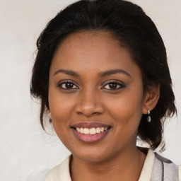 Joyful black young-adult female with medium  brown hair and brown eyes