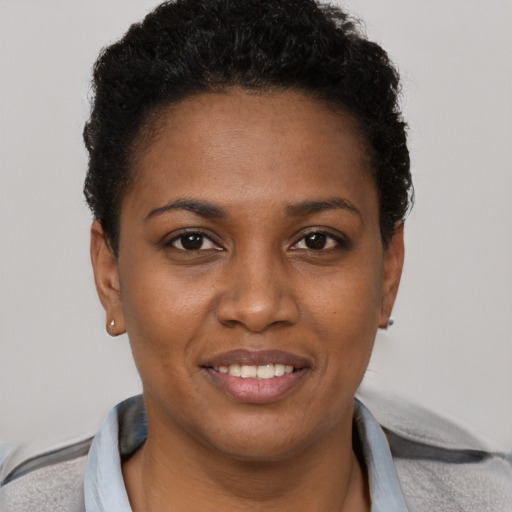 Joyful black young-adult female with short  brown hair and brown eyes