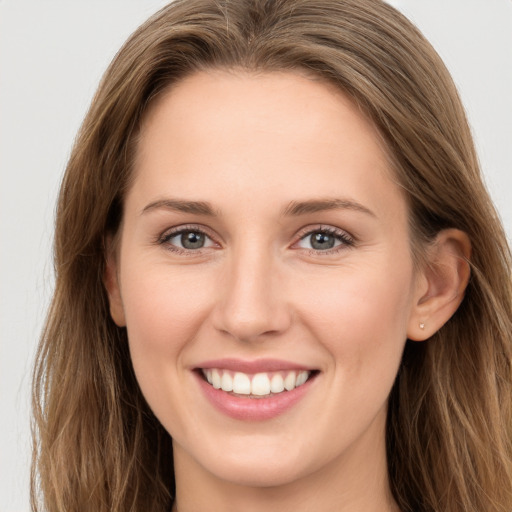 Joyful white young-adult female with long  brown hair and grey eyes