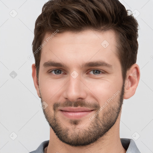 Joyful white young-adult male with short  brown hair and grey eyes