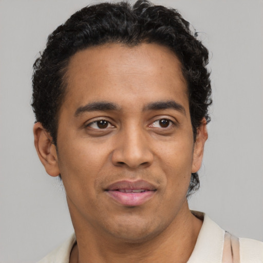 Joyful latino adult male with short  brown hair and brown eyes