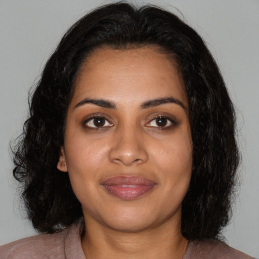 Joyful black young-adult female with medium  black hair and brown eyes