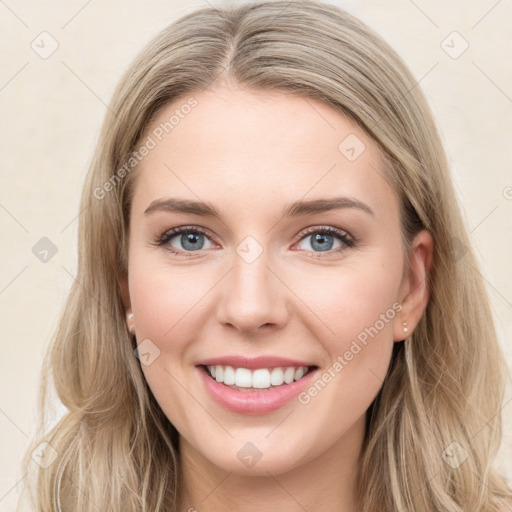 Joyful white young-adult female with long  brown hair and blue eyes