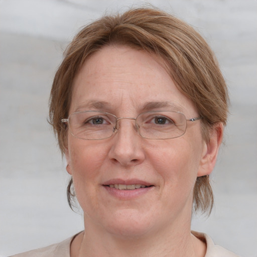 Joyful white adult female with medium  brown hair and blue eyes