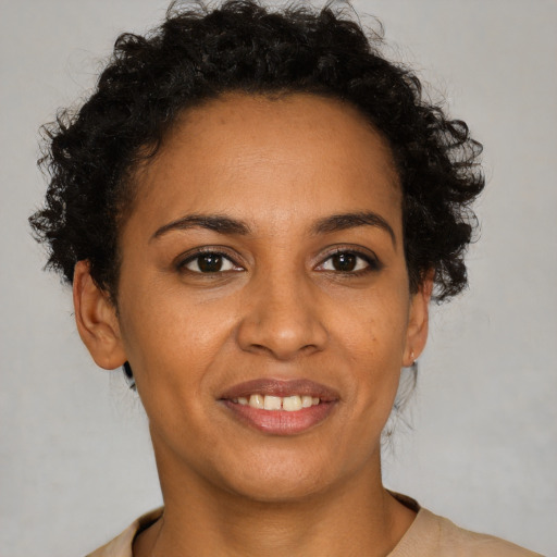 Joyful black adult female with short  brown hair and brown eyes