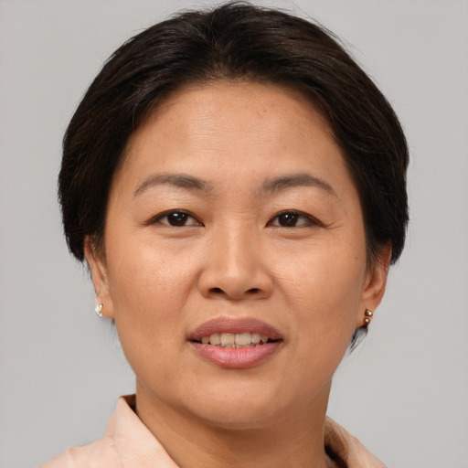 Joyful asian adult female with short  brown hair and brown eyes