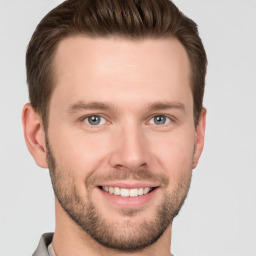 Joyful white young-adult male with short  brown hair and grey eyes