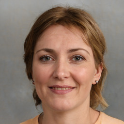 Joyful white adult female with medium  brown hair and grey eyes