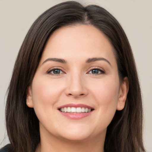 Joyful white young-adult female with long  brown hair and brown eyes