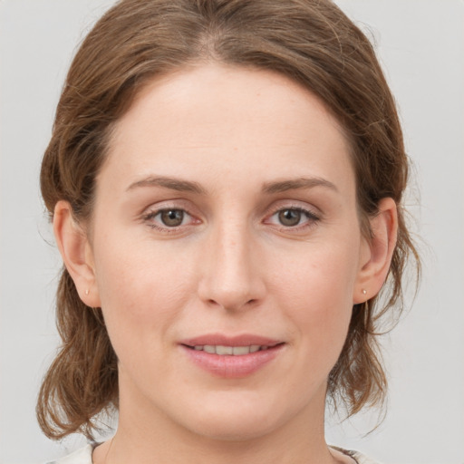 Joyful white young-adult female with medium  brown hair and grey eyes