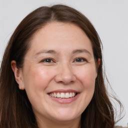 Joyful white adult female with long  brown hair and brown eyes