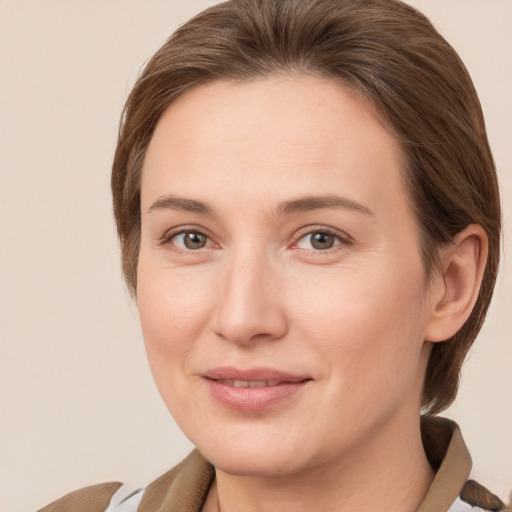 Joyful white young-adult female with medium  brown hair and grey eyes