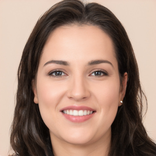 Joyful white young-adult female with long  brown hair and brown eyes