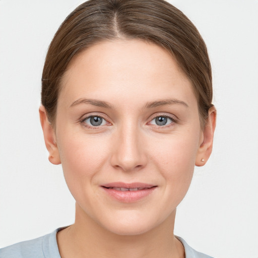 Joyful white young-adult female with short  brown hair and grey eyes