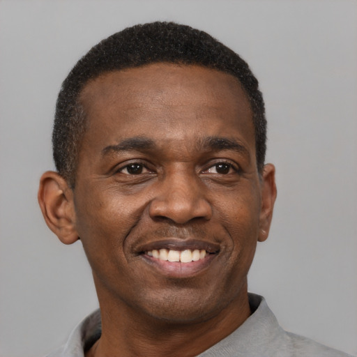 Joyful black young-adult male with short  black hair and brown eyes