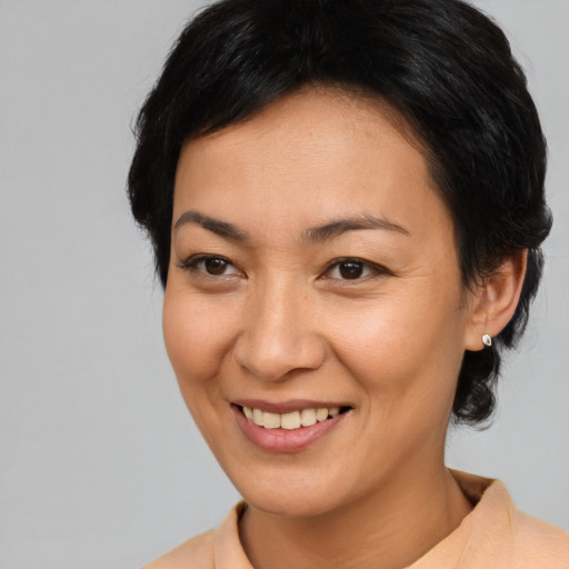 Joyful asian young-adult female with short  brown hair and brown eyes