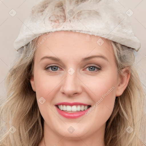 Joyful white young-adult female with long  brown hair and blue eyes