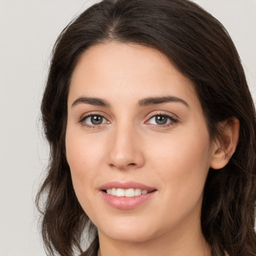 Joyful white young-adult female with long  brown hair and brown eyes