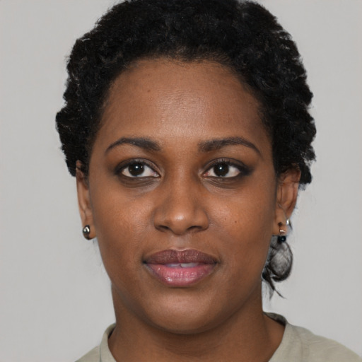 Joyful black young-adult female with short  black hair and brown eyes