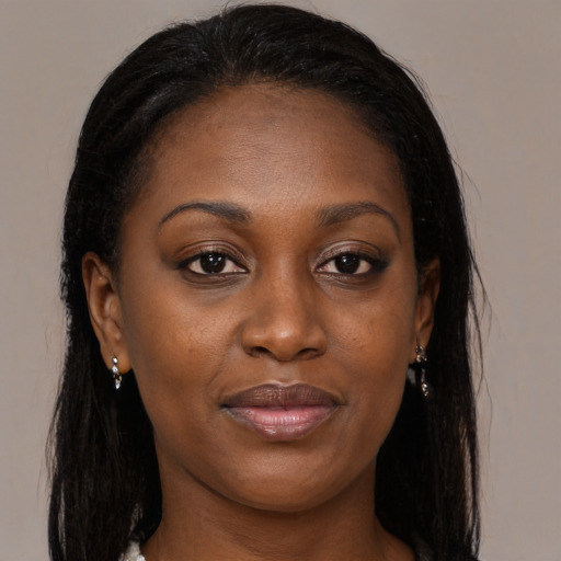 Joyful black young-adult female with long  brown hair and brown eyes