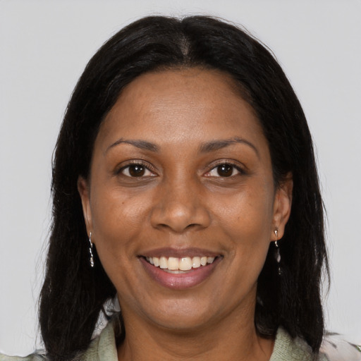Joyful black young-adult female with long  black hair and brown eyes