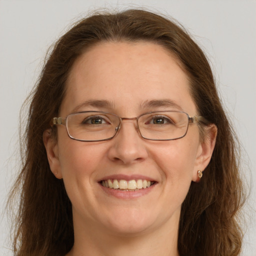 Joyful white adult female with long  brown hair and grey eyes