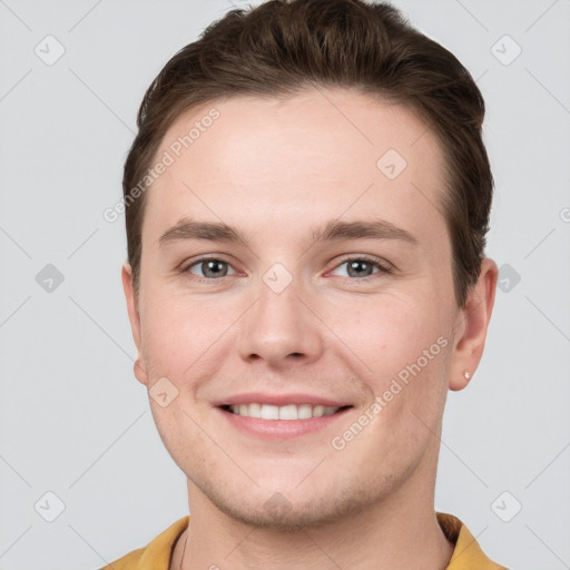 Joyful white young-adult male with short  brown hair and grey eyes