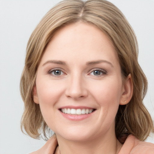 Joyful white young-adult female with medium  brown hair and blue eyes