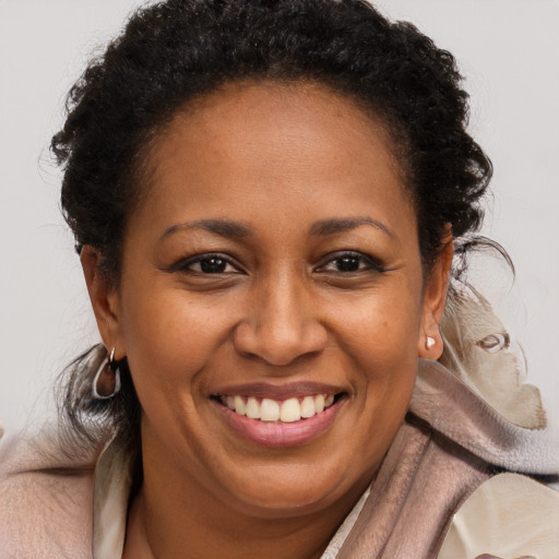 Joyful black adult female with medium  brown hair and brown eyes