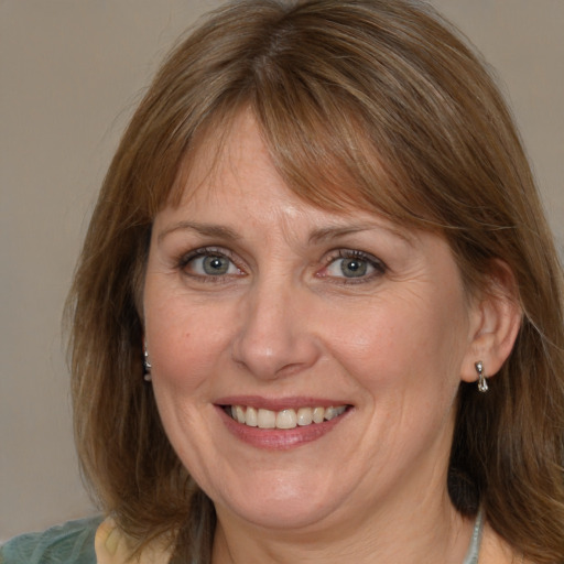 Joyful white adult female with medium  brown hair and grey eyes