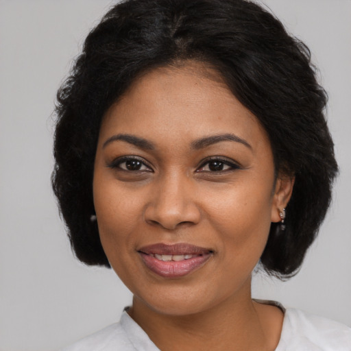 Joyful black young-adult female with medium  brown hair and brown eyes