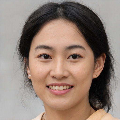 Joyful asian young-adult female with medium  brown hair and brown eyes
