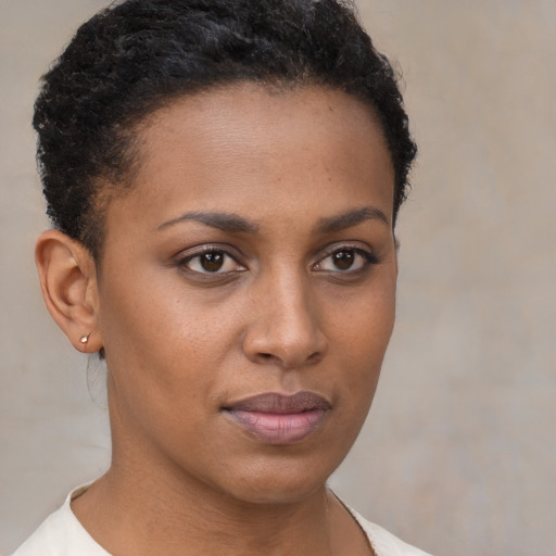 Joyful black young-adult female with short  brown hair and brown eyes