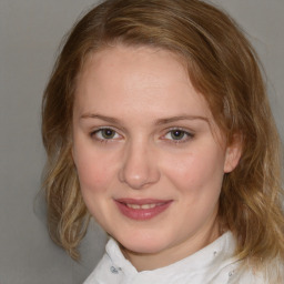 Joyful white young-adult female with medium  brown hair and blue eyes