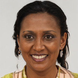 Joyful black adult female with medium  brown hair and brown eyes