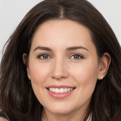 Joyful white young-adult female with long  brown hair and brown eyes