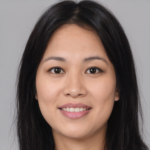 Joyful asian young-adult female with long  brown hair and brown eyes