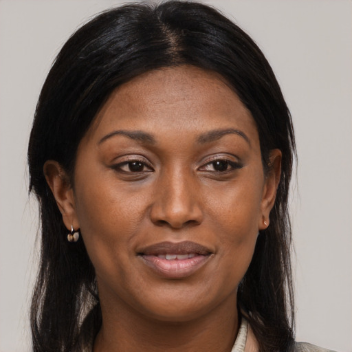 Joyful black young-adult female with long  brown hair and brown eyes